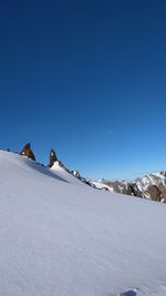 Snow covered mountain against blue sky