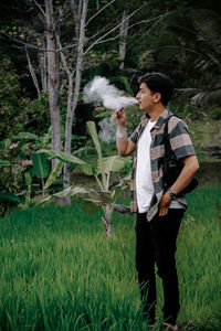 Portrait of young man standing on field