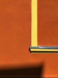 Close-up of yellow wall with orange door