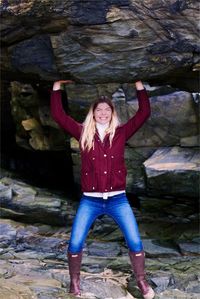 Portrait of smiling young woman standing on rock