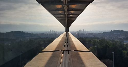 Bridge over river in city against sky