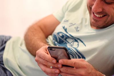 Midsection of man using mobile phone