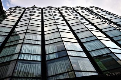 Low angle view of modern glass building against sky