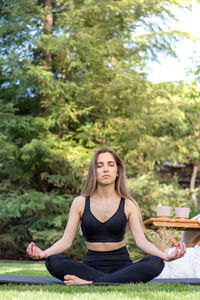 Vertical view of young woman enjoying her meditation moment time in the garden with copy space