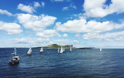 Sailboats sailing on sea against sky