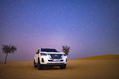 Car on road against sky at night