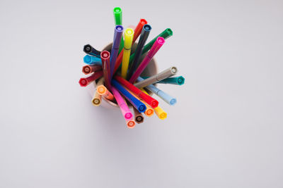 High angle view of colored pencils against white background