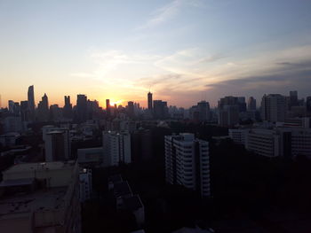 Buildings in city against sky during sunset