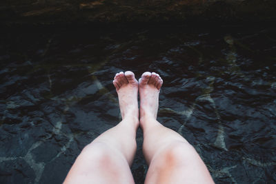 Low section of woman legs in water