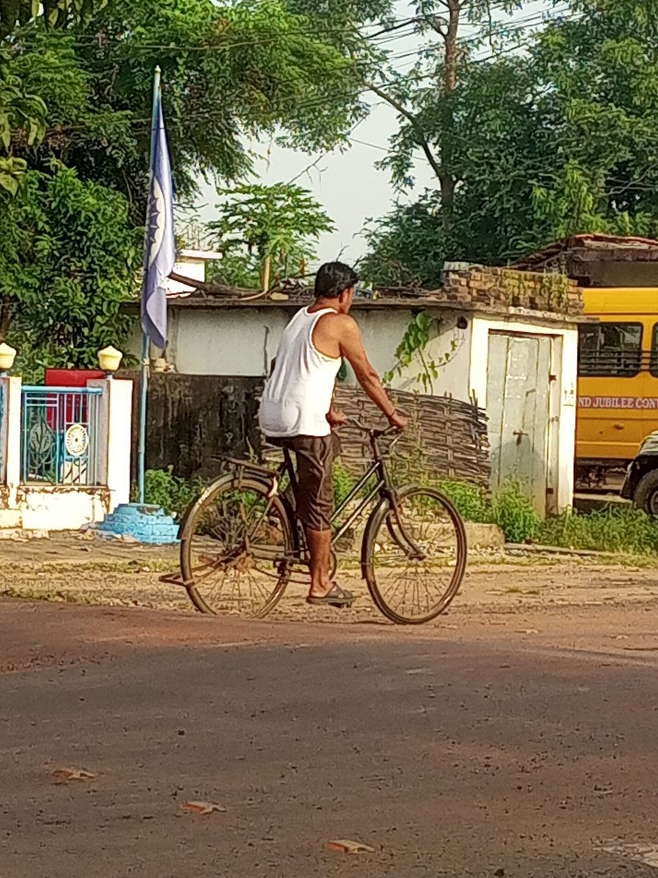 transportation, bicycle, mode of transportation, one person, land vehicle, tree, full length, plant, vehicle, adult, men, lifestyles, nature, city, casual clothing, sports equipment, day, road, architecture, leisure activity, street, cycling, sports, outdoors, young adult, motion, riding, travel, built structure, rear view, activity, cycle sport, person, rickshaw, bicycle wheel, building exterior