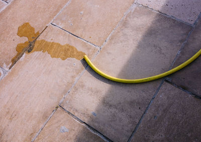 High angle view of yellow shadow on tiled floor