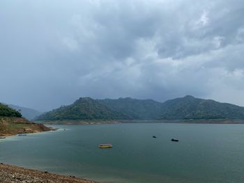 Scenic view of sea and mountains against sky