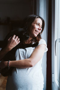 Portrait of a smiling young woman standing at home