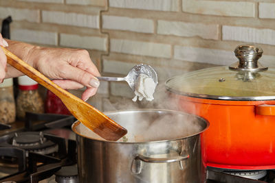 Fresh cream is thrown into pan on gas stove according to recipe from the internet. steam pot