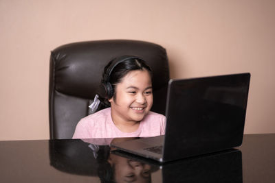 Portrait of smiling girl using mobile phone at home