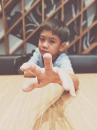 Portrait of boy gesturing at table in restaurant