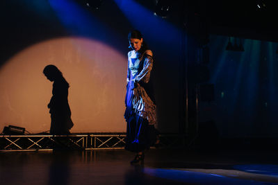 Full length of man standing on illuminated stage