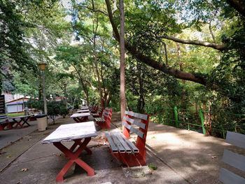 Empty chairs and table against trees in forest