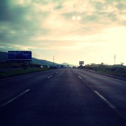 Empty road against cloudy sky