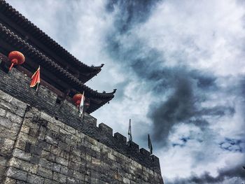 Low angle view of building against cloudy sky