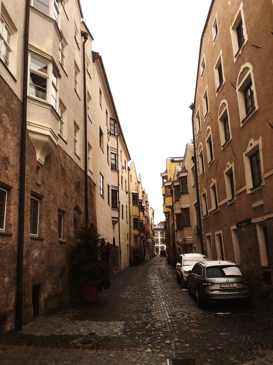 EMPTY ROAD AMIDST BUILDINGS IN CITY