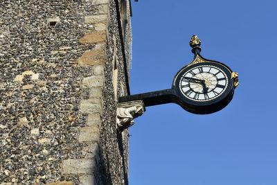 Low angle view of clock against clear sky