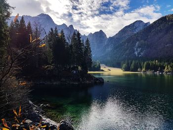 Scenic view of lake by mountains against sky