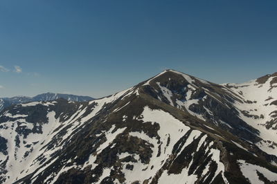 Scenic view of snowcapped mountains against clear sky