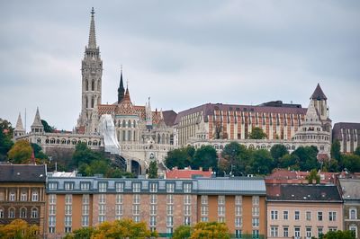 Buildings in city against cloudy sky