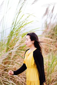 Side view of young woman looking at plants