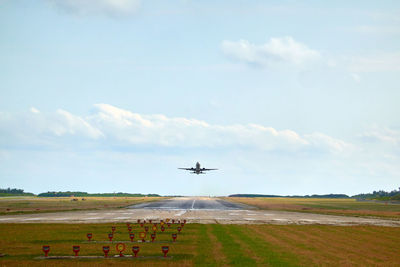 Airplane taking off from runway against sky