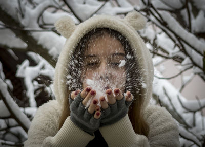 Close-up of girl blowing snow