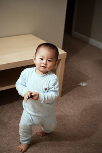 Portrait of cute baby boy walking at home