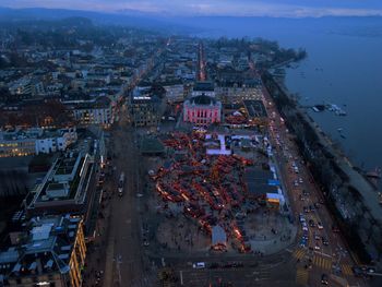 Aerial view of city by sea at dusk