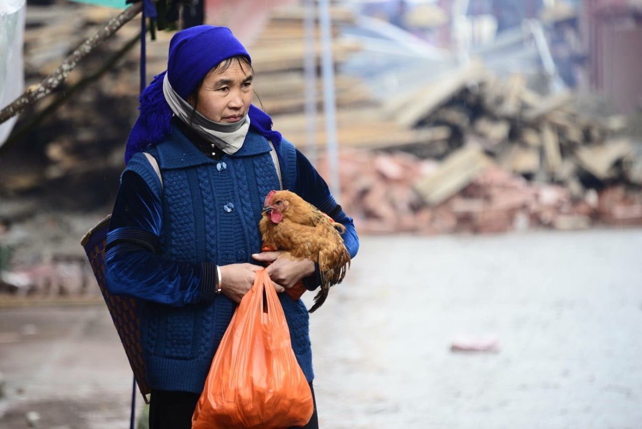 PORTRAIT OF A YOUNG MAN HOLDING A ROOSTER