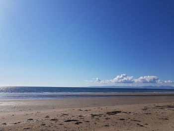 Scenic view of beach against blue sky