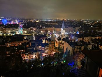 High angle view of illuminated buildings against sky at night