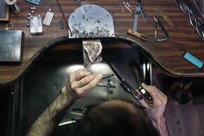 Cropped hands of person using flame torch at workshop