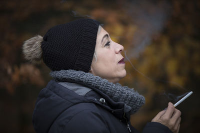 Close-up of woman using mobile phone during winter