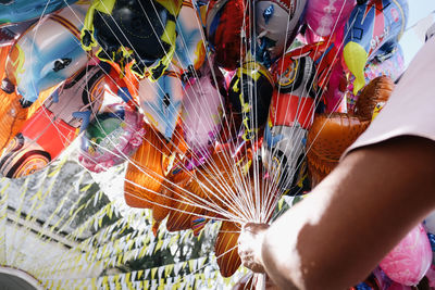 Cropped image of seller holding balloons