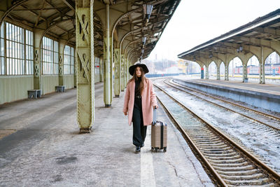 Woman traveler tourist walks with luggage at the train station. the concept of