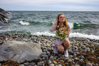 Portrait of young woman sitting at beach