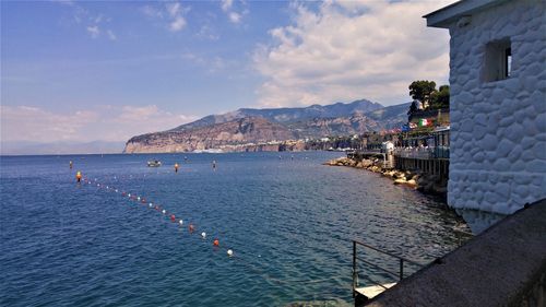 Scenic view of sea by buildings against sky