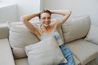 Young woman sitting on sofa at home