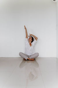 Rear view of woman sitting on floor