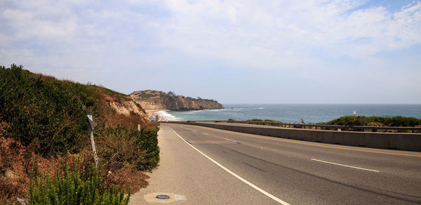 Road by sea against sky