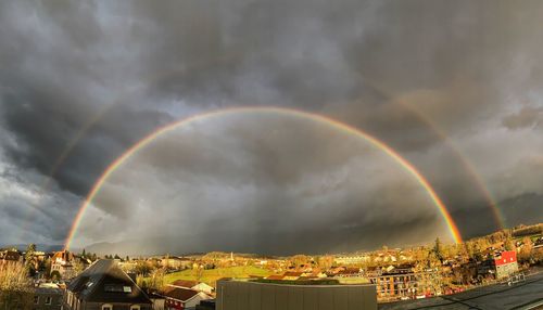 Rainbow over building against sky