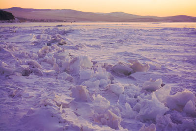 Scenic view of frozen sea against sky during sunset