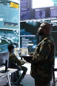 Rear view of man using laptop