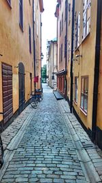 Empty alley amidst buildings in city